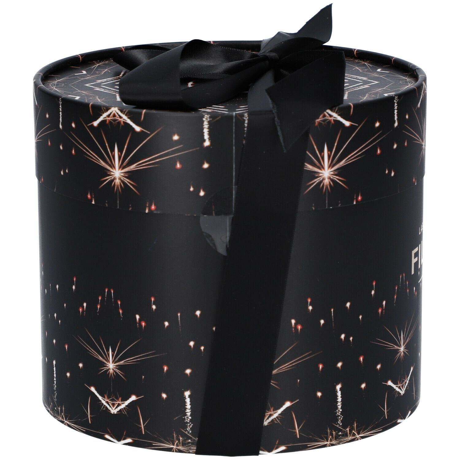 Zylindrische Geschenkbox mit schwarzem Band. Schwarzer Hintergrund mit goldenen Sternen. Aufschrift FILORGA PARIS. Etikett mit Produktinformationen.