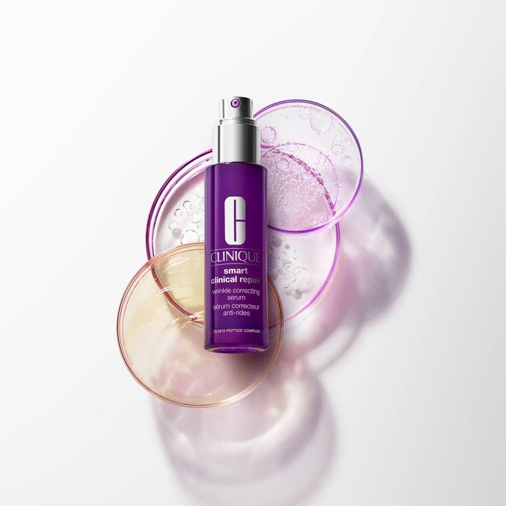 Flacon de sérum violet. Sur verrerie de laboratoire. Sur fond clair.