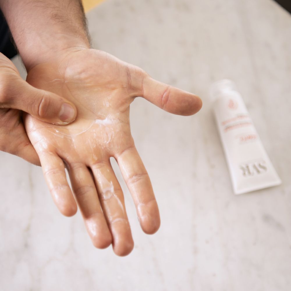Handen met aangebrachte SVR CICAVIT+ handcrème. Crème is zichtbaar.