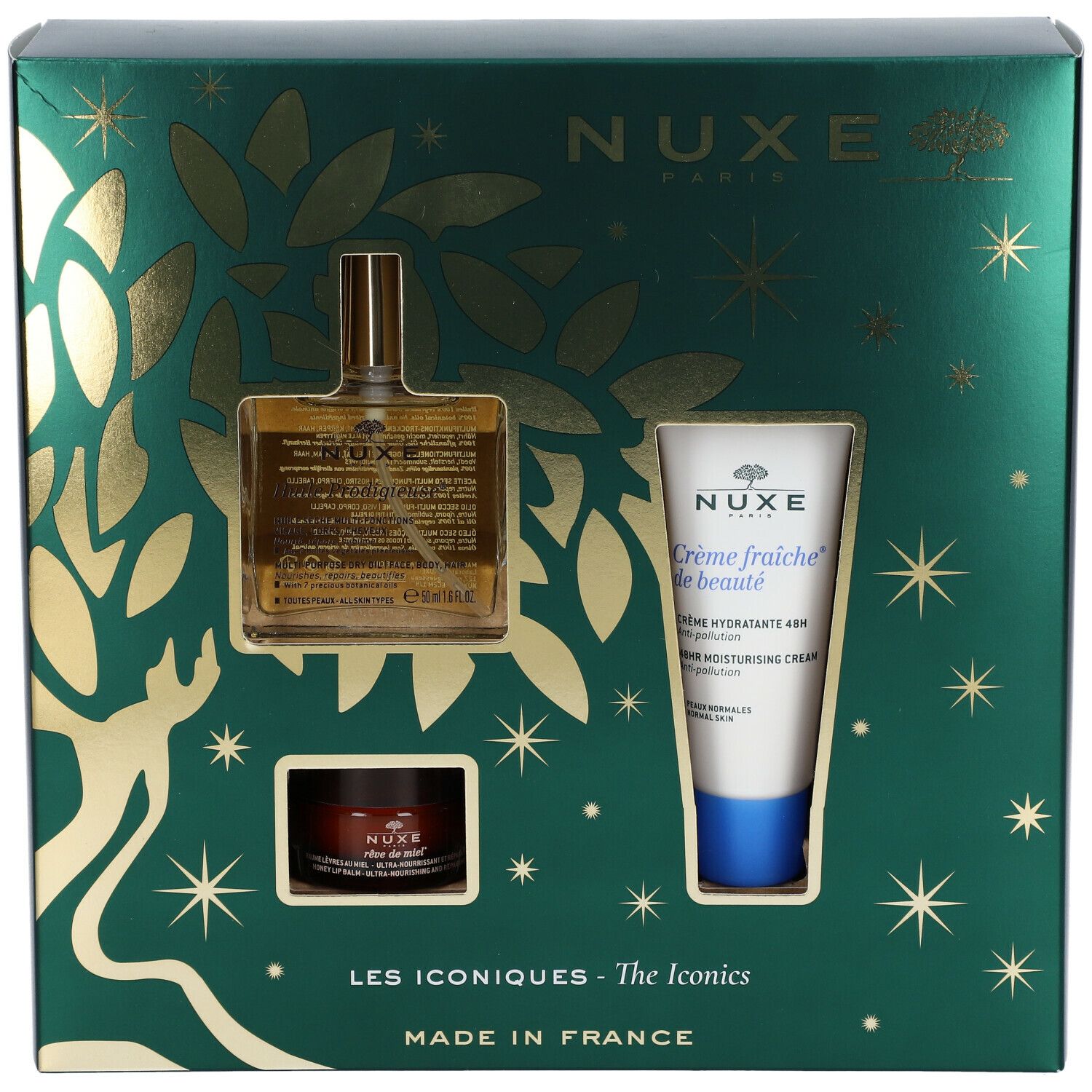Coffret cadeau vert avec produits cosmétiques. Visibles : flacon d'huile, crème et pot. Décorations dorées et étoiles. Logo Nuxe.