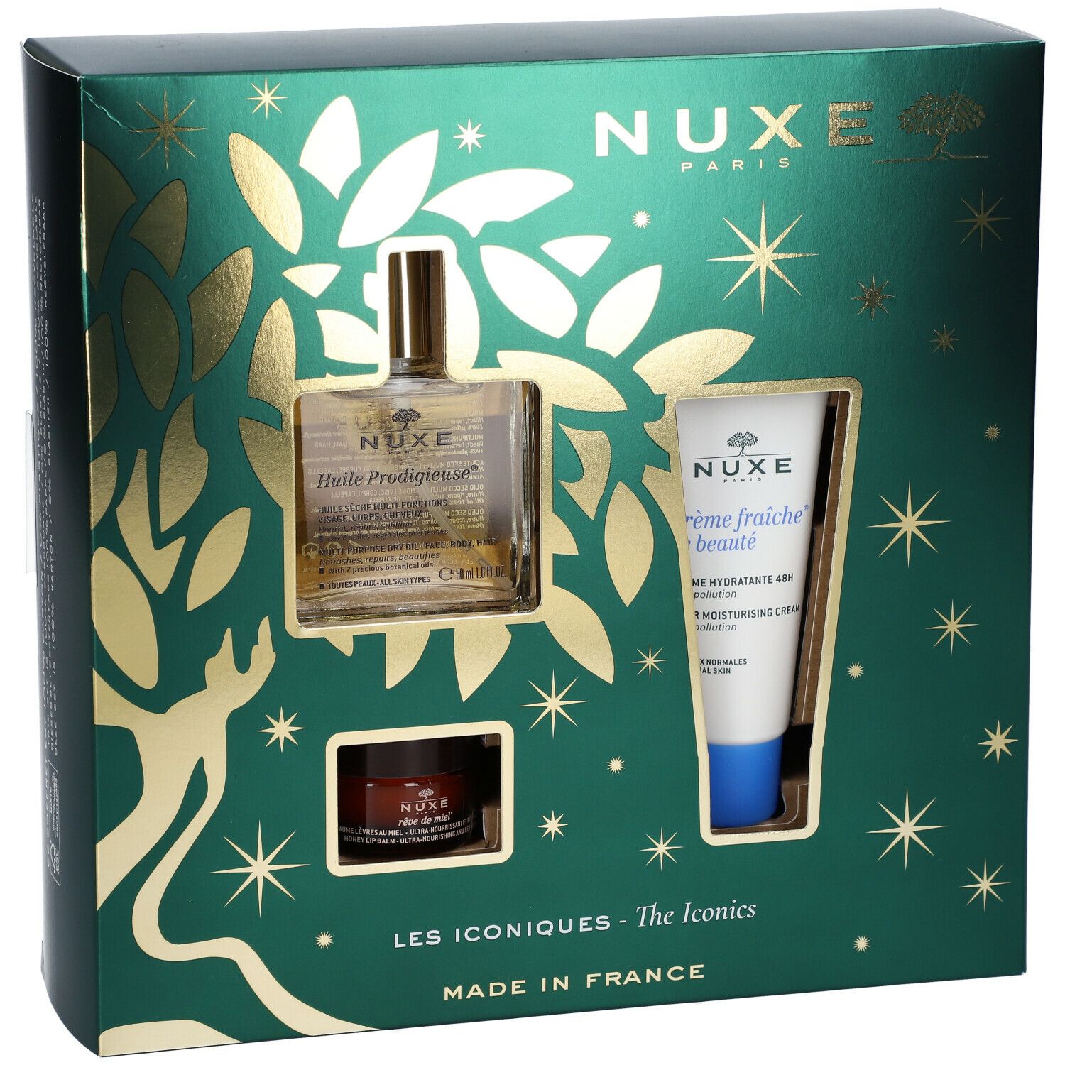 Coffret cadeau vert avec produits cosmétiques. Visibles : flacon d'huile, crème et pot. Décorations dorées et étoiles. Logo Nuxe.