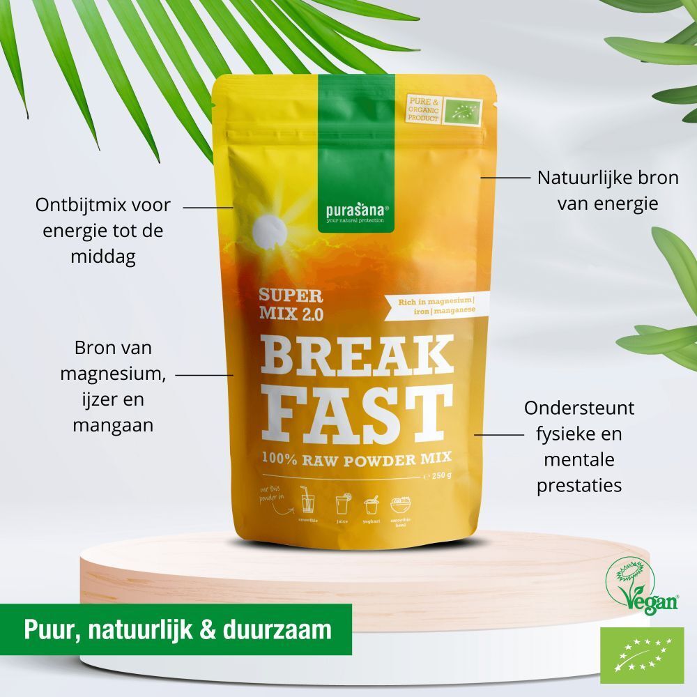 Gele verpakking "Purasana Breakfast Mix 2.0" op sokkel. Tekst: "Super Mix 2.0 Breakfast 100% Raw Powder Mix". Vegan-label.