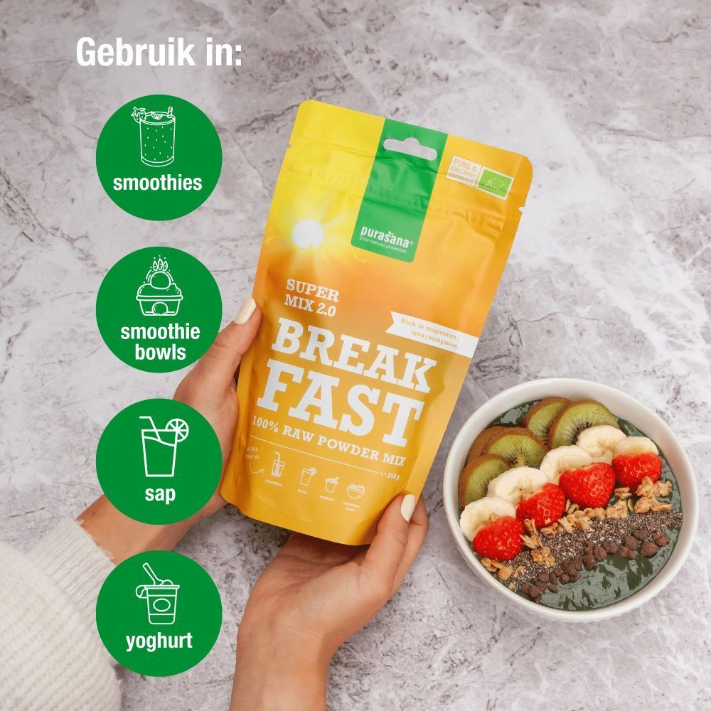 Hand met smoothie bowl en Purasana verpakking. Tekst: "Super Mix 2.0 Breakfast 100% Raw Powder Mix".