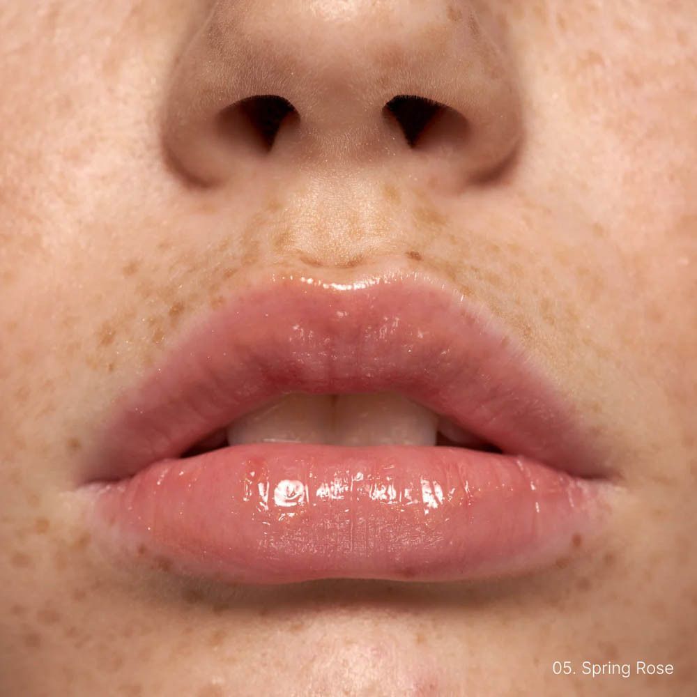 Gevormde lippen met glanzende, roze lipgloss. Tekst: 05. Spring Rose.