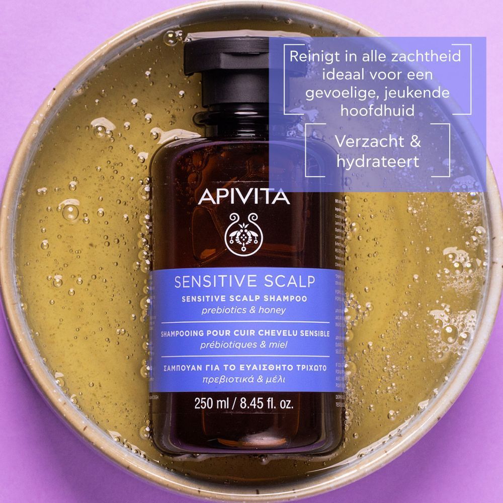 Bruine fles met zwarte dop in een kom. Tekst: APIVITA, Sensitive Scalp Shampoo, 250 ml.