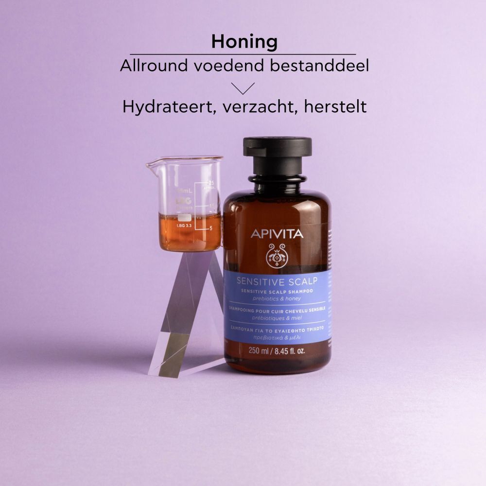Fles, bekerglas. Tekst: APIVITA, Sensitive Scalp Shampoo, 250 ml. Honing, hydrateert, verzacht, herstelt.