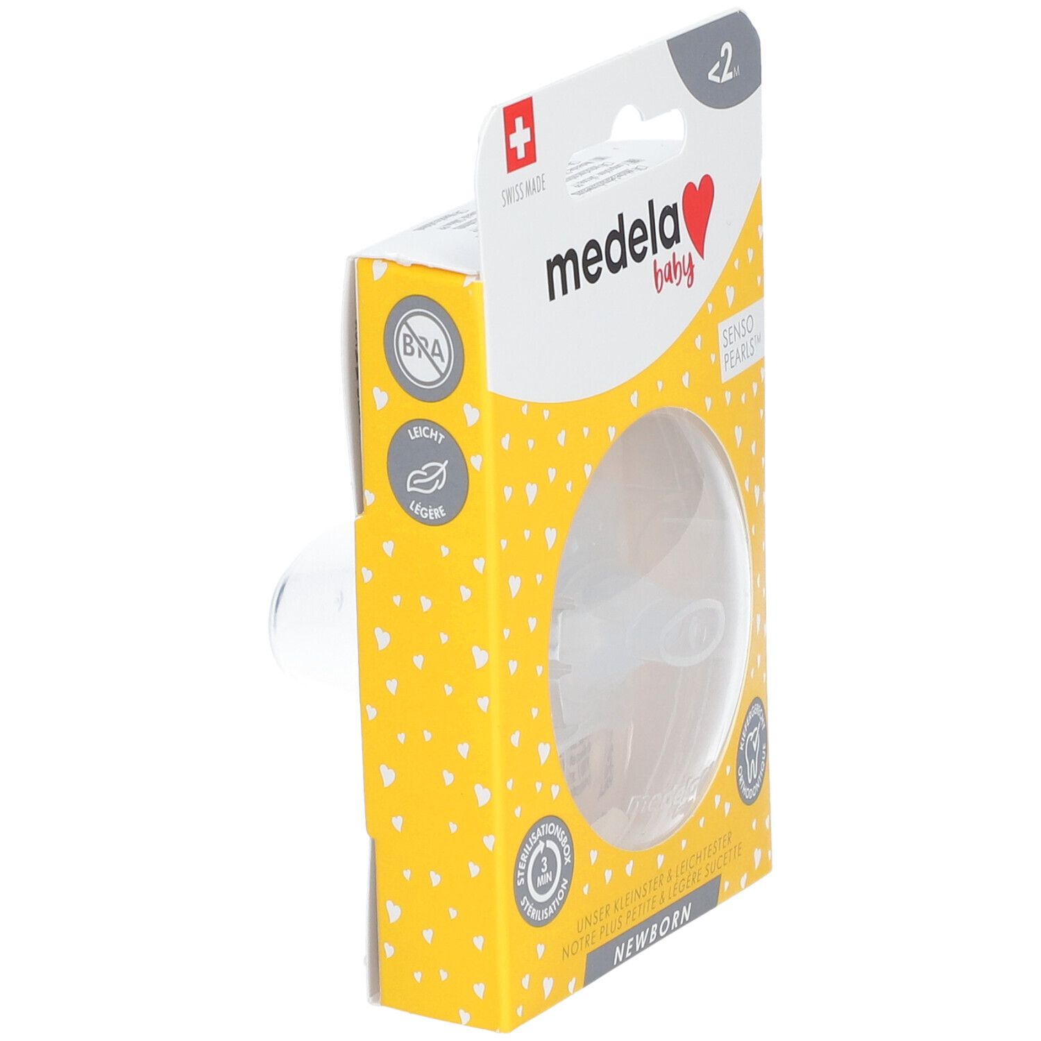 Sucette Medela Baby dans son emballage. Boîte jaune à motifs cœurs. Produit partiellement visible. Texte: Newborn, Senso Pearls.