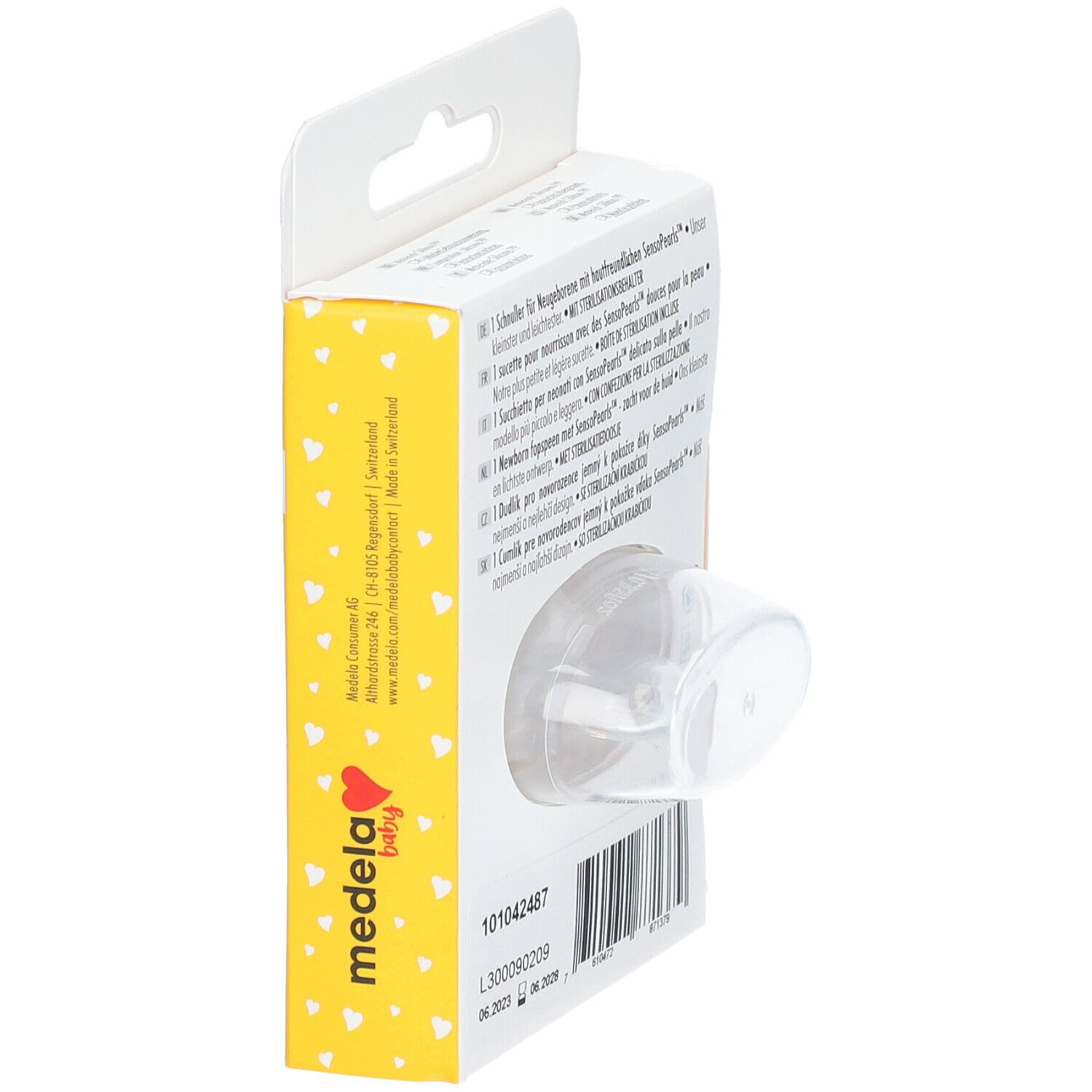 Sucette Medela Baby dans son emballage. Boîte jaune à motifs cœurs. Produit partiellement visible. Texte: Newborn, Senso Pearls.