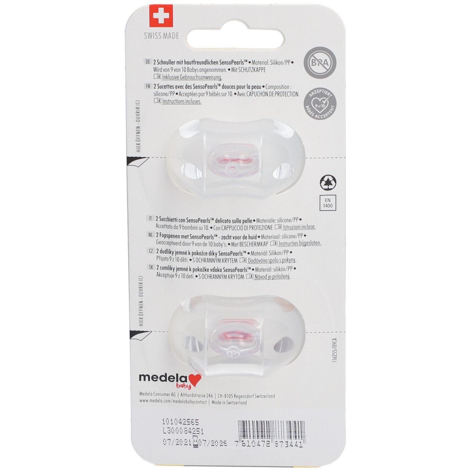 Rückseite der Verpackung mit zwei Schnullern. Transparente Schnuller mit roter Spitze. Informationen zu Material und Zertifizierungen.