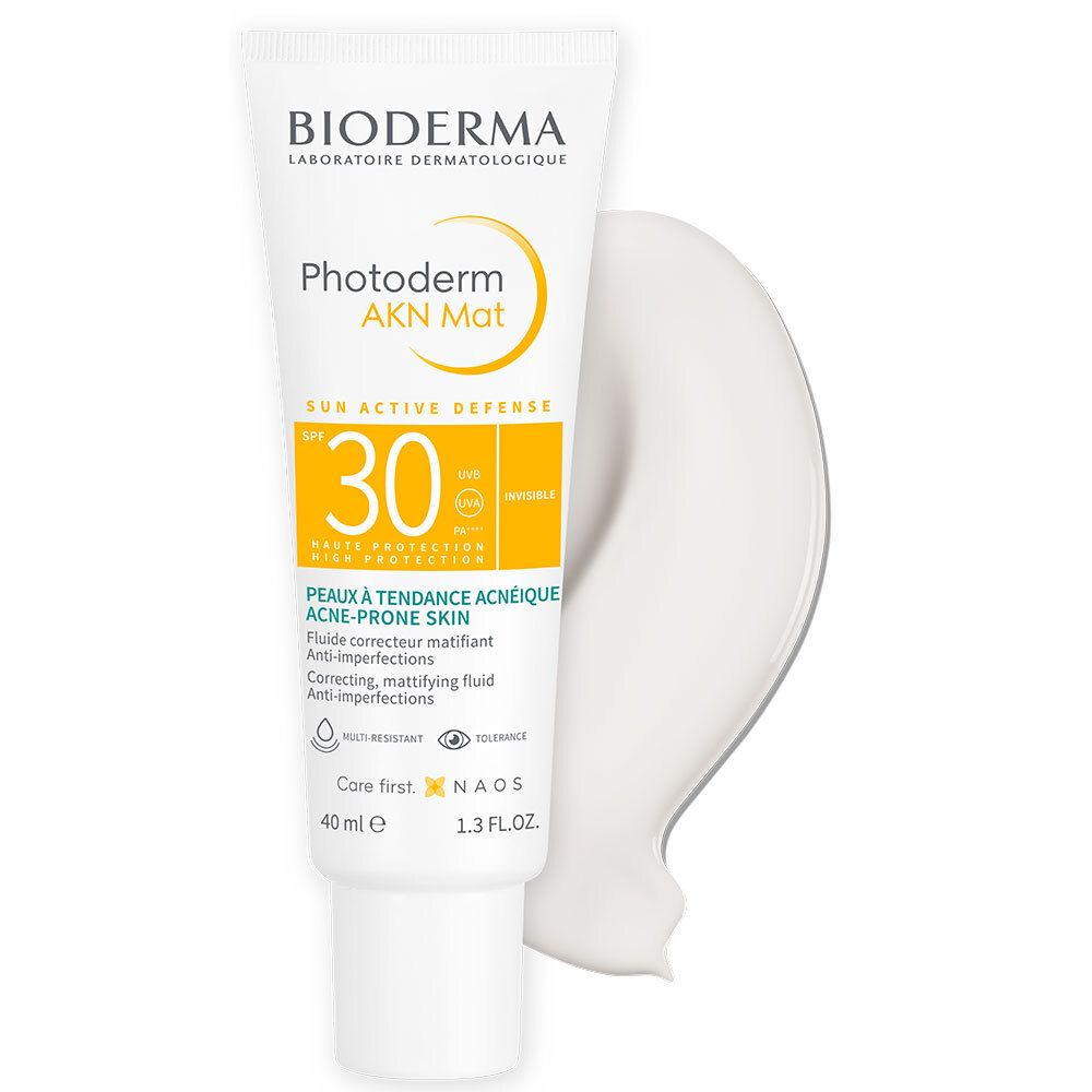 Witte tube met BIODERMA Photoderm AKN Mat SPF30. Geel en wit. Product aangebracht.
