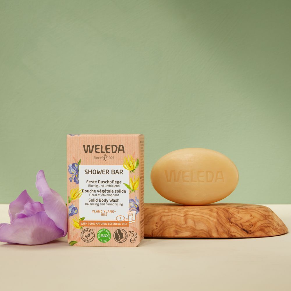 Vaste douche Ylang-Ylang + Iris en zeep op houten plank. Verpakking en zeep met logo en bloemmotieven.