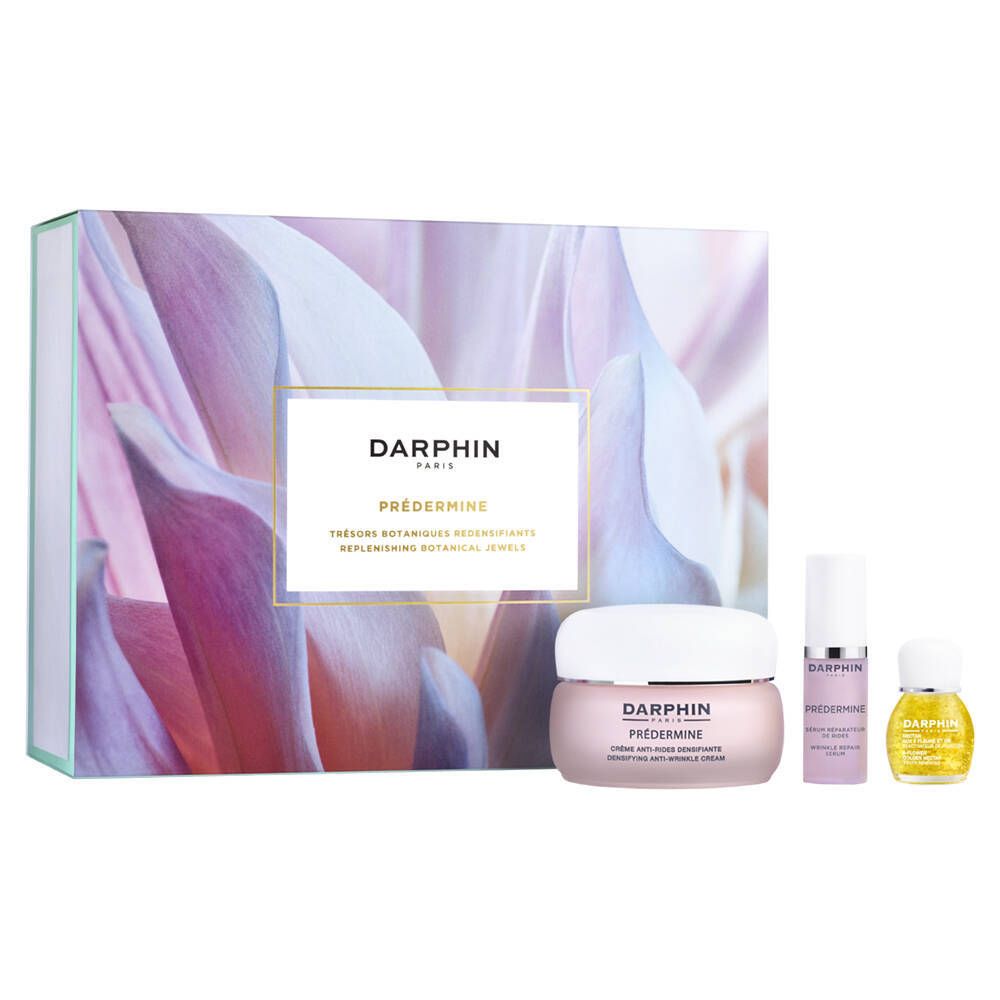 Geschenkset mit Creme, Serum und Öl. Verpackung mit floralem Muster und Produktnamen.