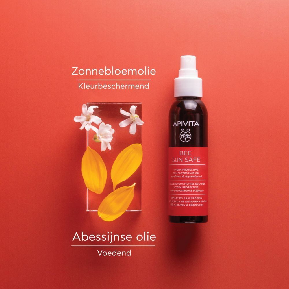 Productfles en ingrediënten op rode achtergrond. Zonnebloemolie en abyssinie-olie.