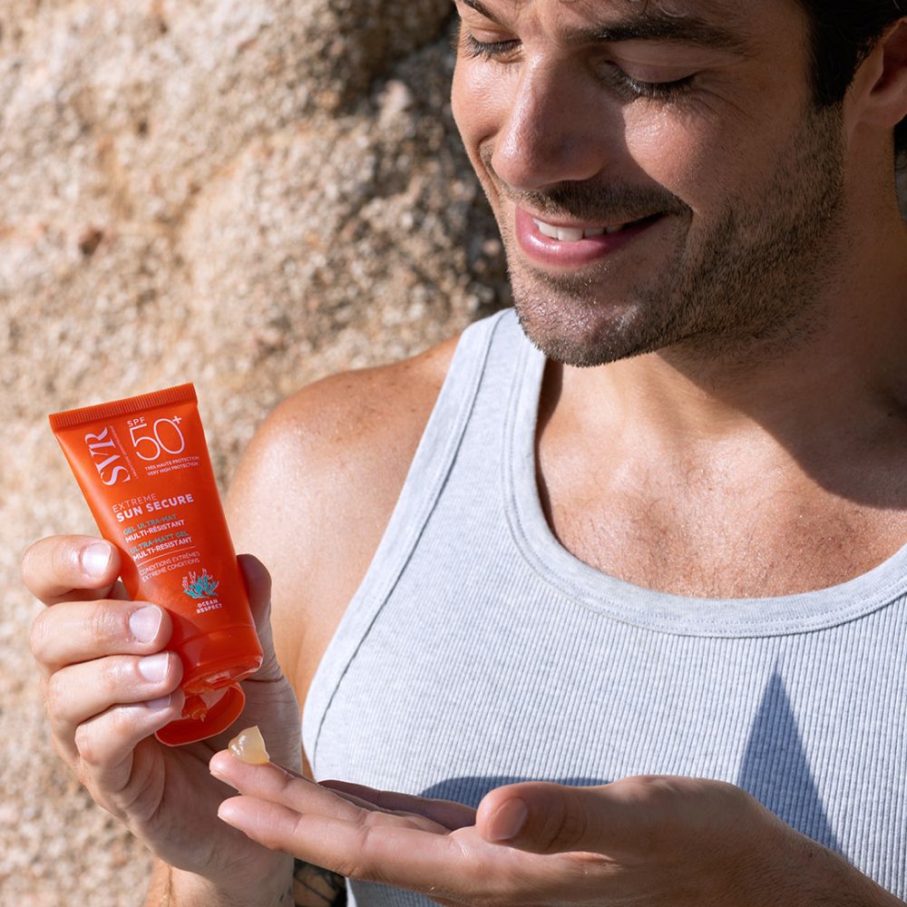 Homme tenant un tube et un échantillon de gel. Logo SVR, SPF 50+, Extreme Sun Secure.