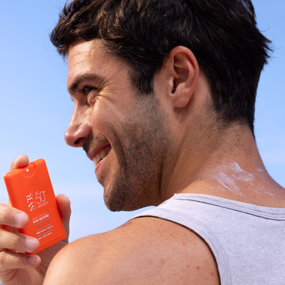Man brengt oranje SVR SUN SECURE Pocket Spray aan op zijn rug.
