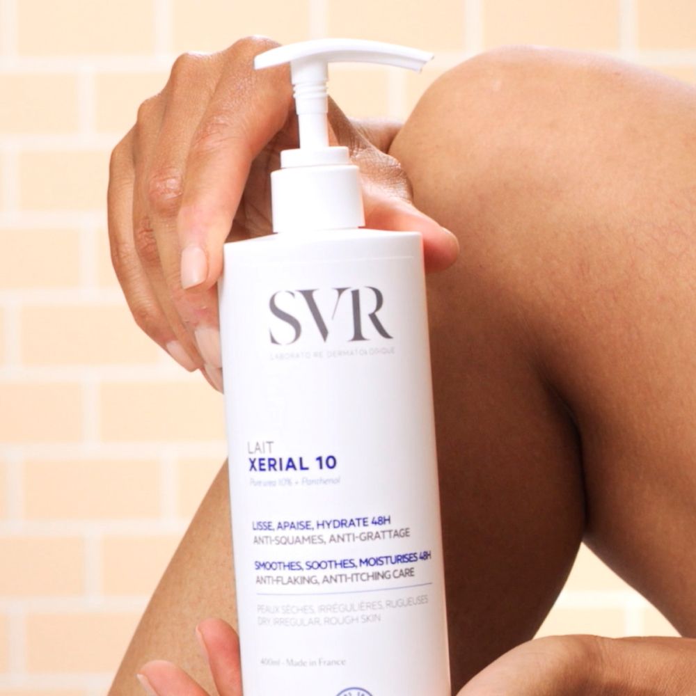 Persoon houdt witte fles met pomp vast. Opschrift: SVR, XERIAL 10. Toepassing op been.