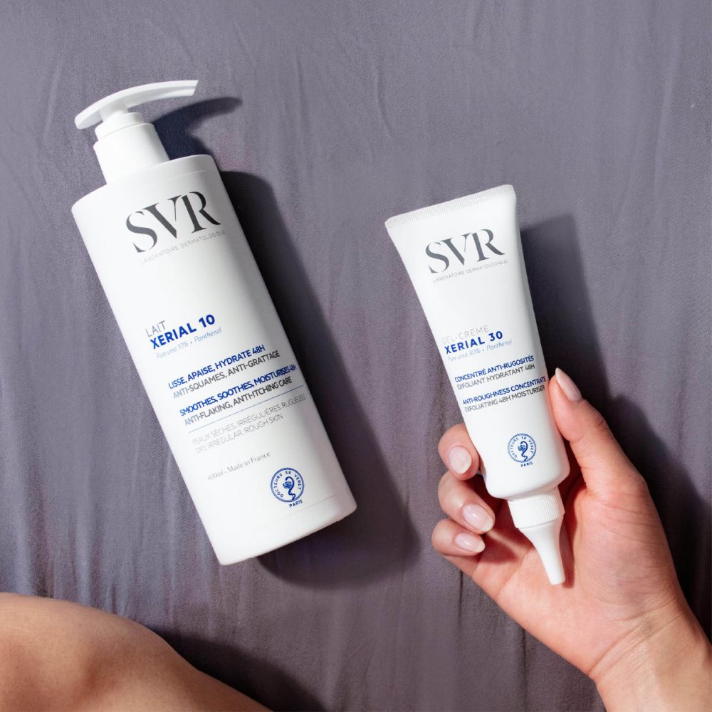 Deux produits: SVR XERIAL 10 lotion et SVR XERIAL 30 crème. Sur surface grise.