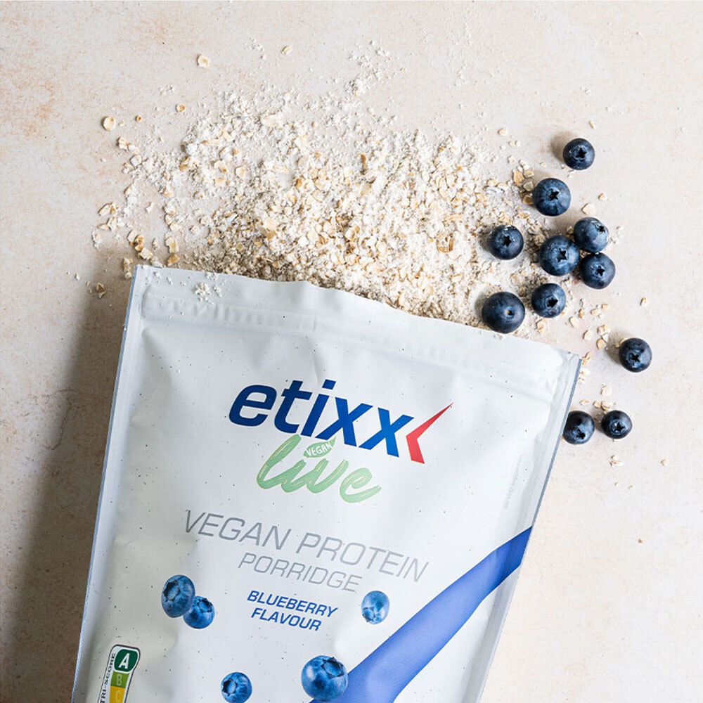 Sachet 'etixx live Vegan Protein Porridge Blueberry'. Myrtilles et flocons d'avoine dispersés. Impression avec étiquetage nutritionnel.