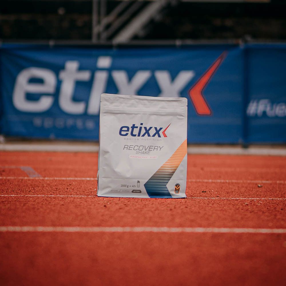 Zak "etixx Recovery Shake" op rode atletiekbaan. Logo en productnaam zichtbaar.