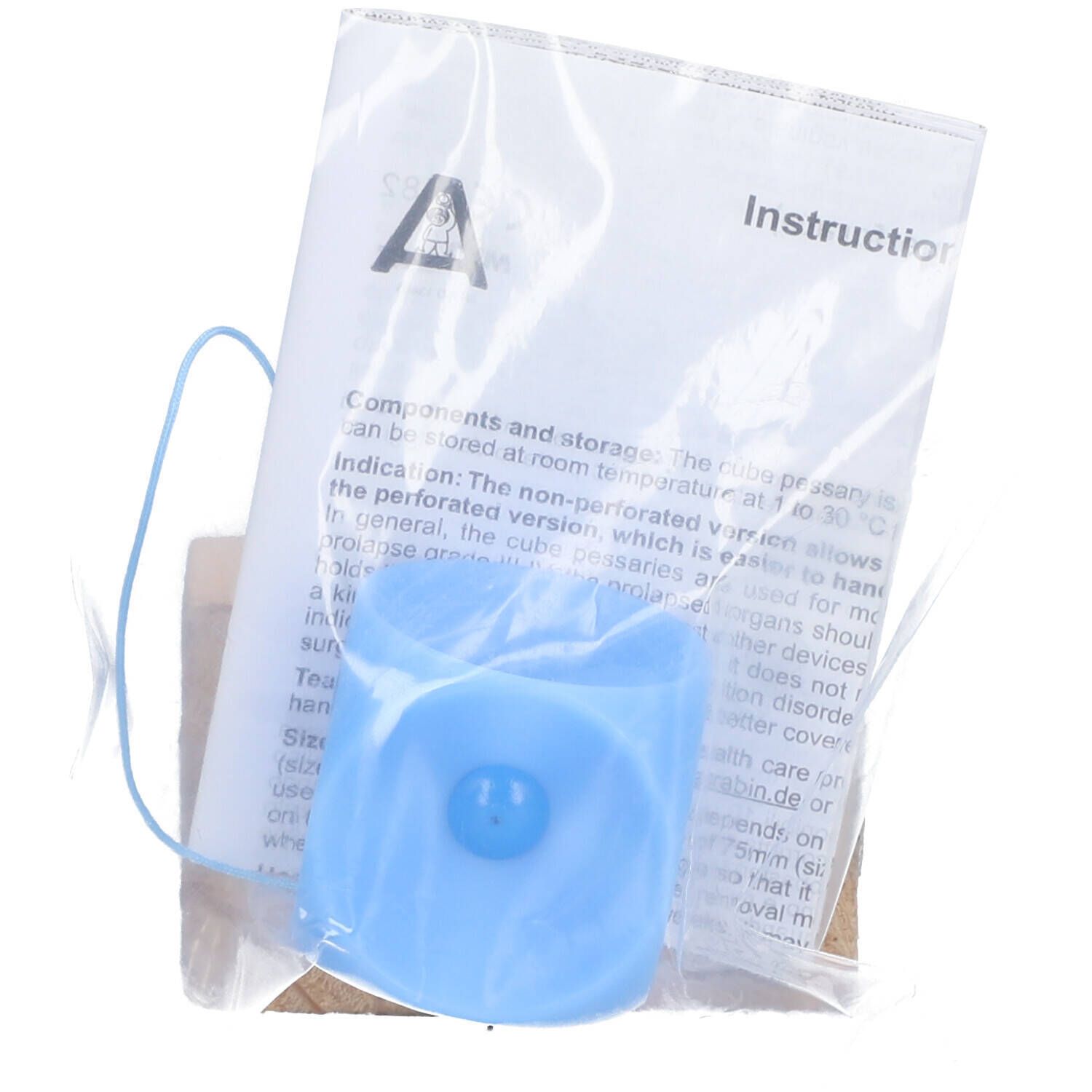 Pessaire bleu dans un sachet avec notice. Le pessaire est en forme de cube avec bouton.