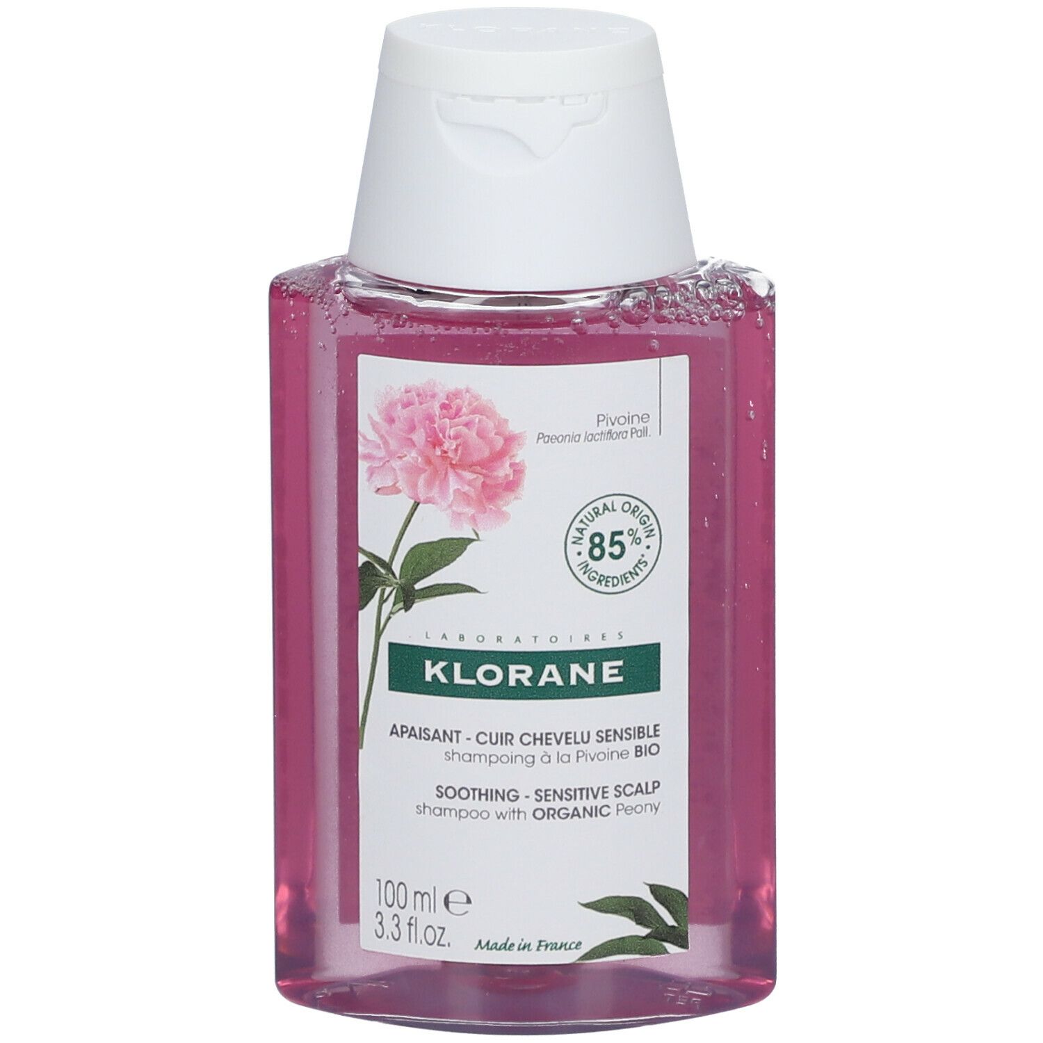 Flasche KLORANE Shampoo mit Pfingstrose BIO. Rosa Flüssigkeit, weißer Deckel. Etikett mit Blüte und Text.