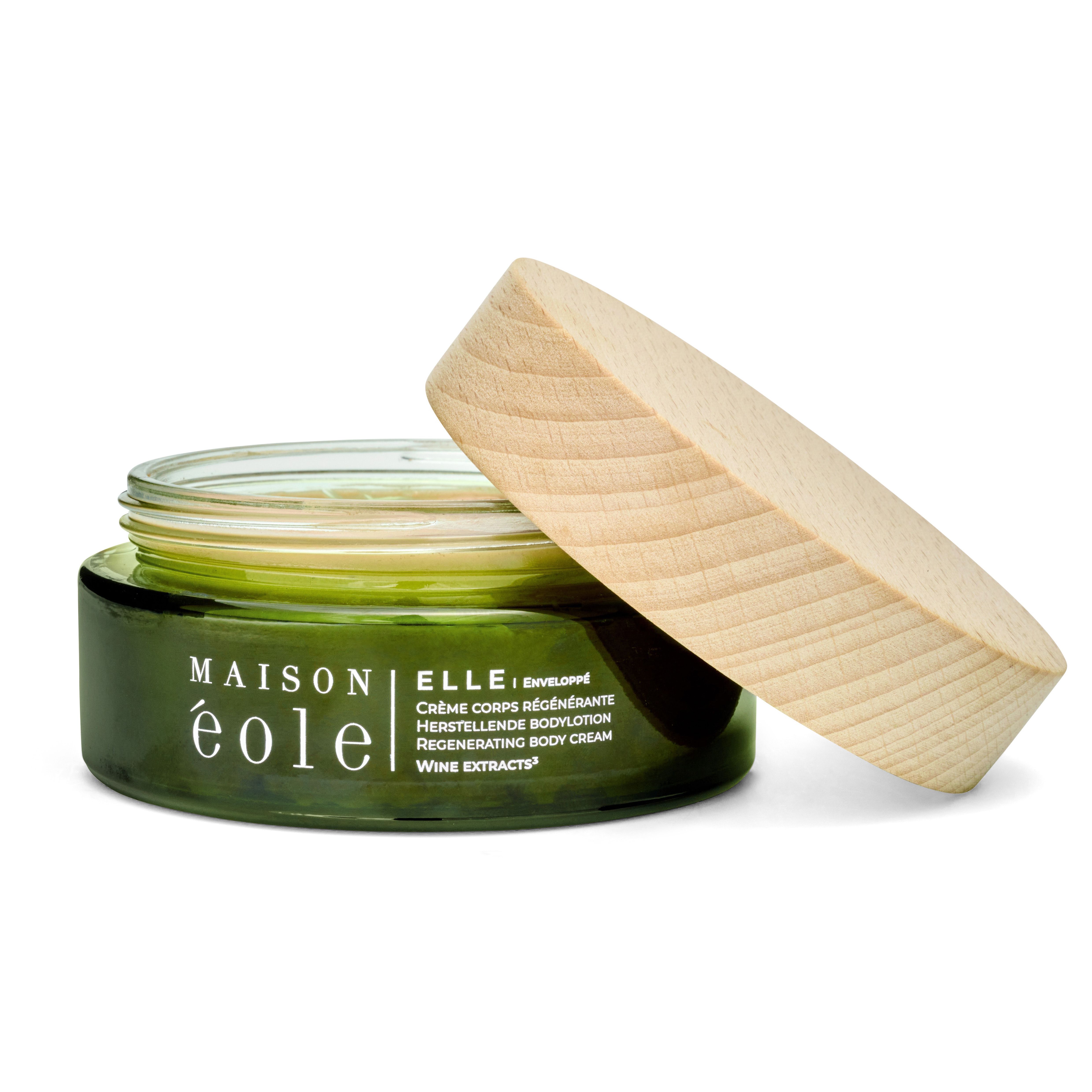 Grünes Glas mit Holzdeckel, Deckel geöffnet. Aufschrift: Maison éole, Crème Corps Régénérante, Herstellende Bodylotion, Regenerating Body Cream.