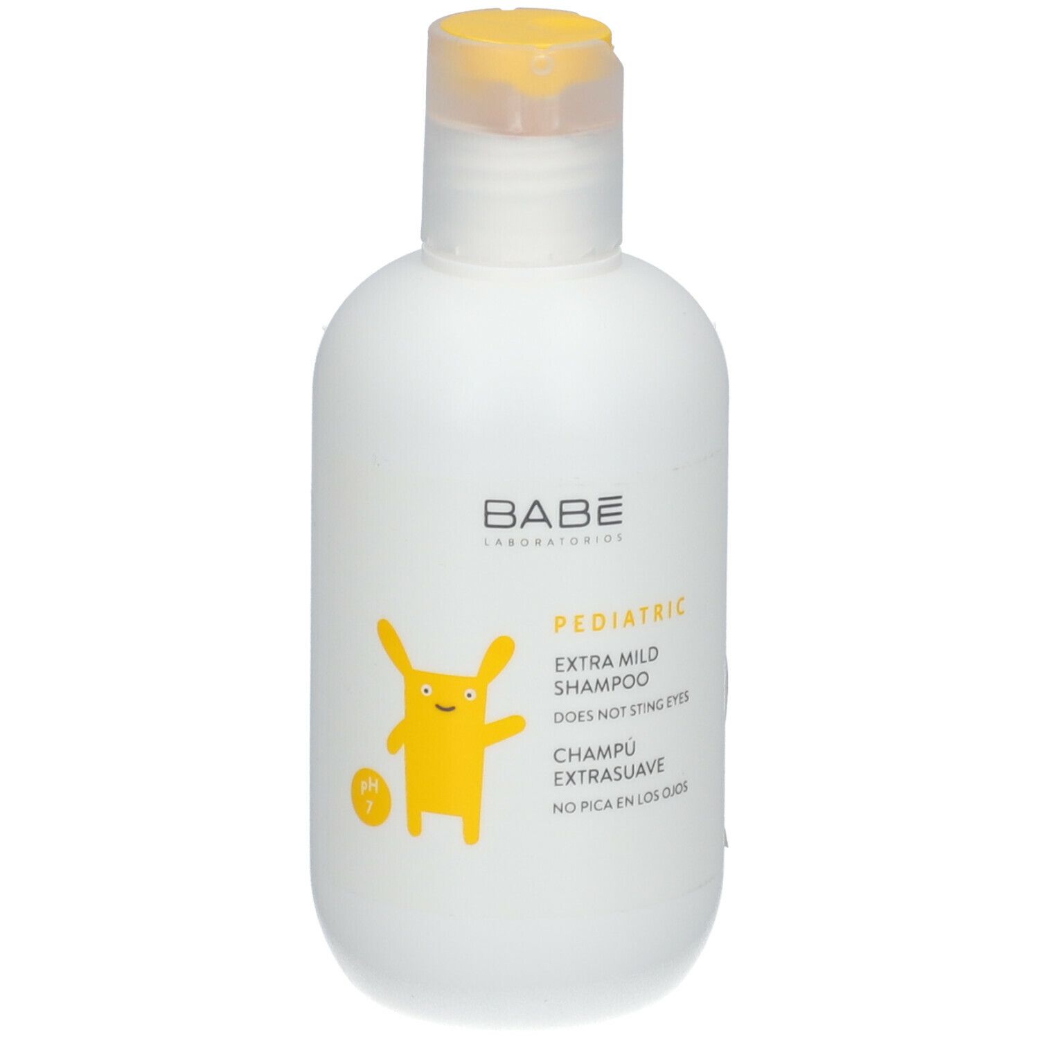 Witte fles met gele klapdop. Opschrift: Babé Laboratorios, Pediatric Extra Mild Shampoo. Geel cartoonfiguur.