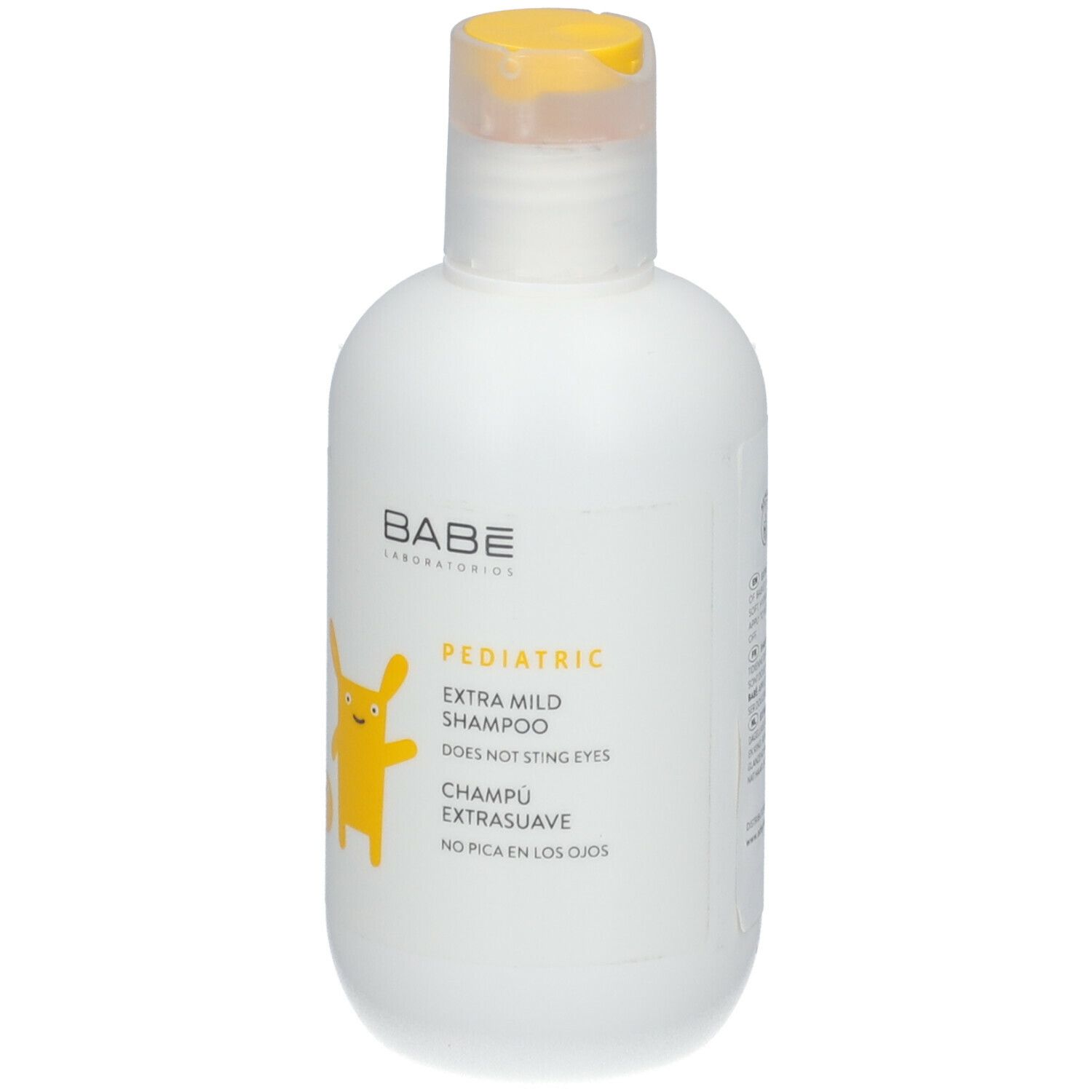 Witte fles met gele klapdop. Opschrift: Babé Laboratorios, Pediatric Extra Mild Shampoo. Geel cartoonfiguur.