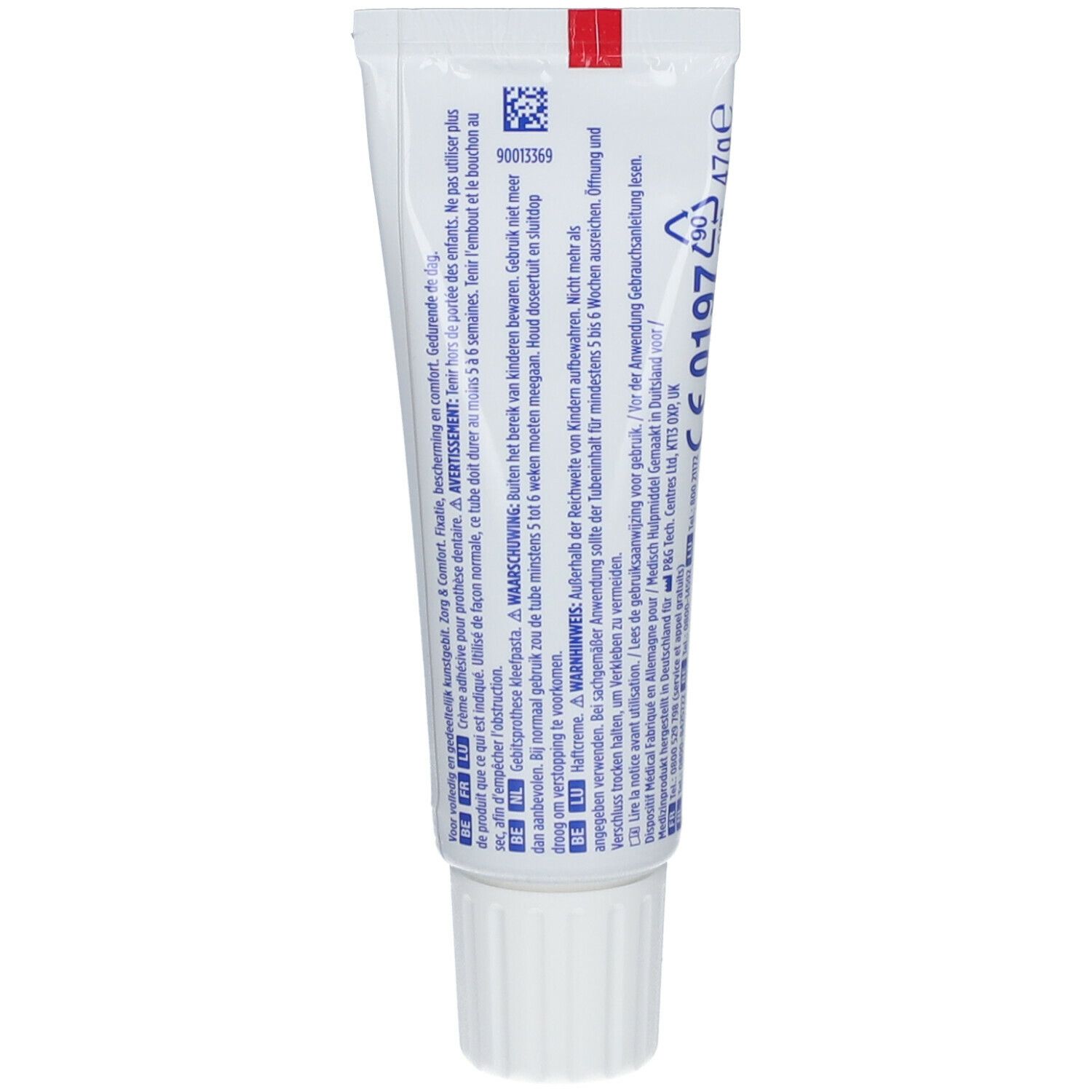 Dos d'un tube de crème adhésive. Texte multilingue. Code-barres, marquage CE et avertissements.