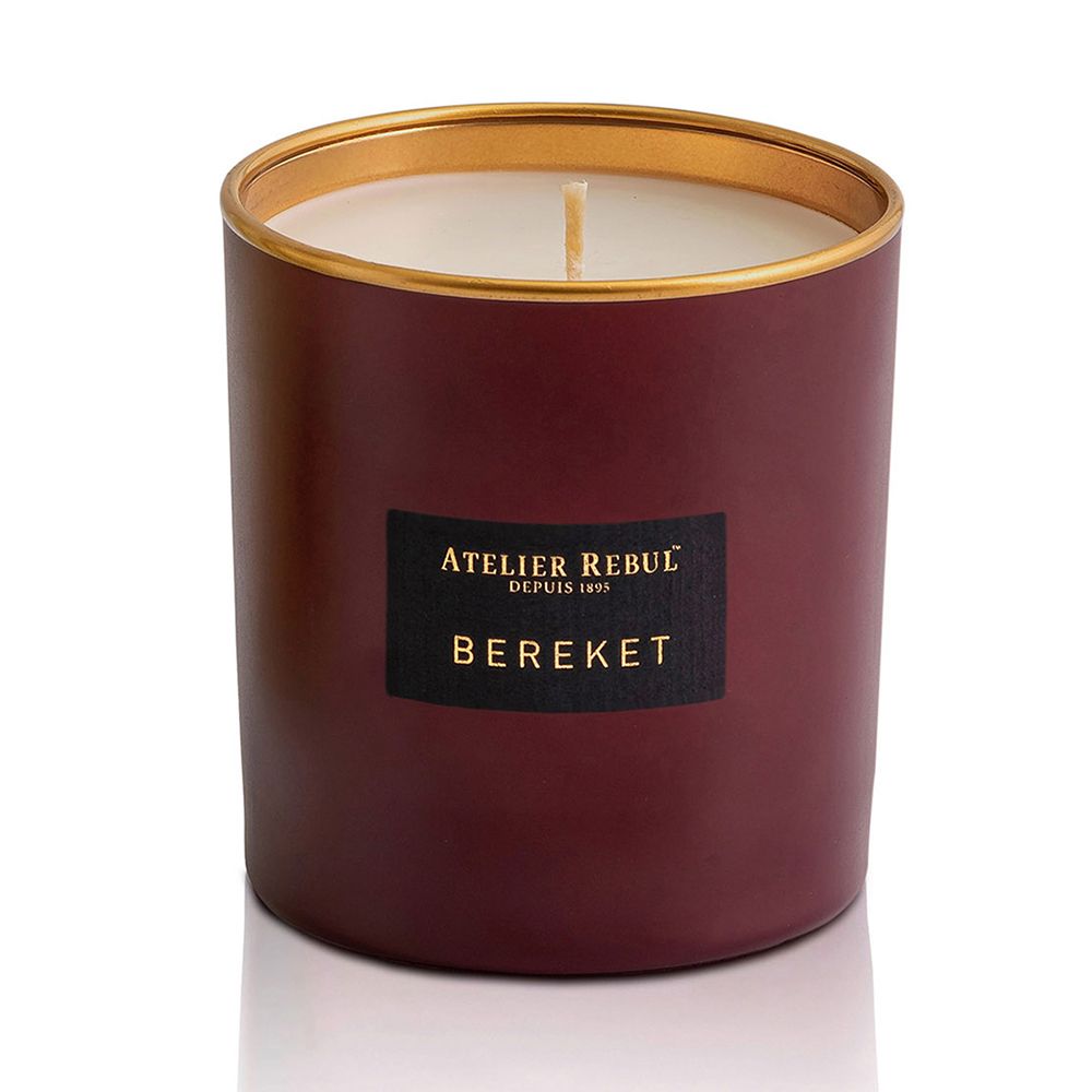 Bordeauxfarbene Kerze mit goldfarbenem Rand und schwarzem Etikett. Text: ATELIER REBUL, BEREKET.