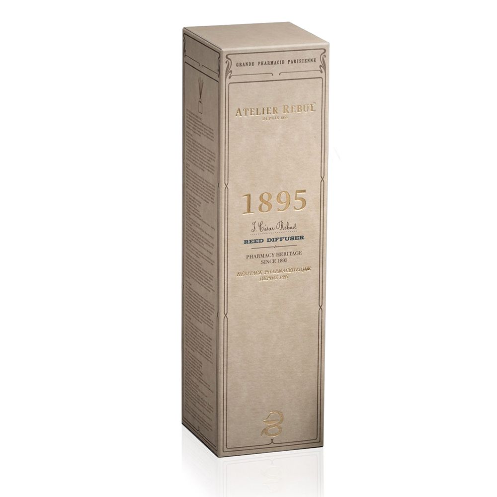 Hohe, rechteckige Kartonverpackung. Aufschrift: ATELIER REBUL 1895. Beige-braune Farbe.