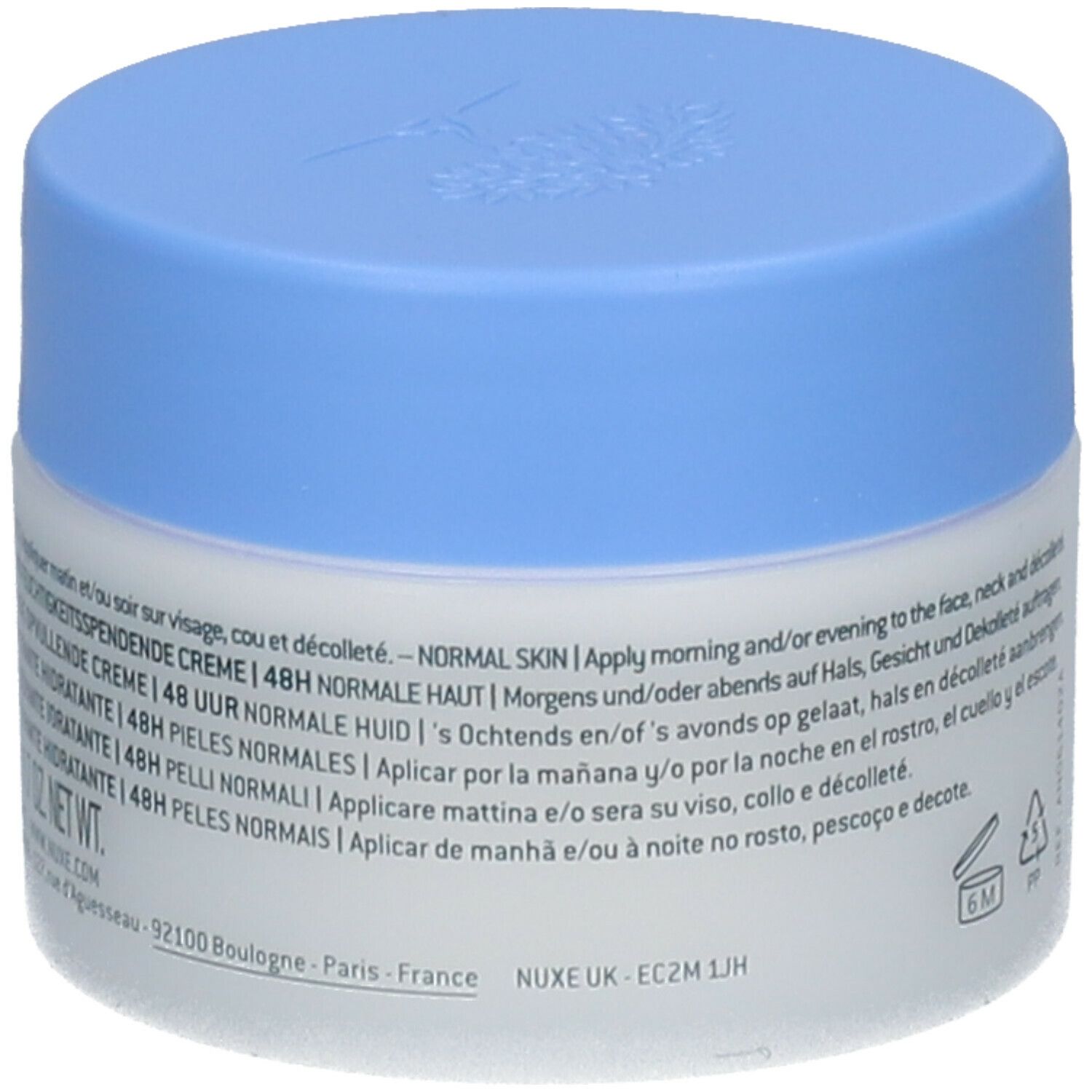 Pot de crème avec couvercle bleu. Inscription : Nuxe UK, texte avec instructions d'utilisation. Symboles de durabilité.