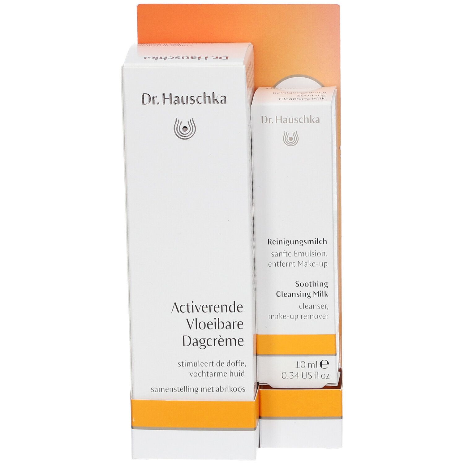 Twee Dr. Hauschka productverpakkingen. Eén doos met "Aktivierende Vloeibare Dagcrème", de andere met "Reinigingsmelk".