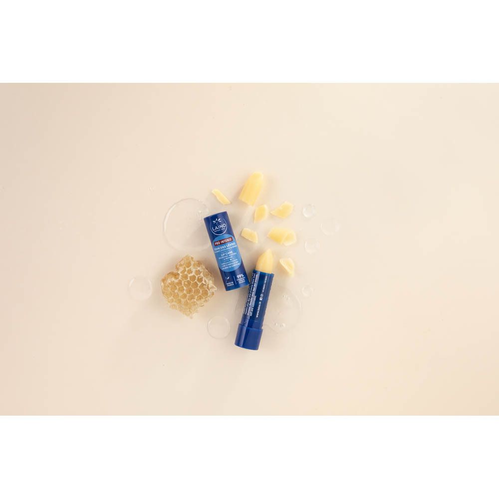 Deux sticks de soin des lèvres bleus avec rayons de miel et cire sur fond beige.