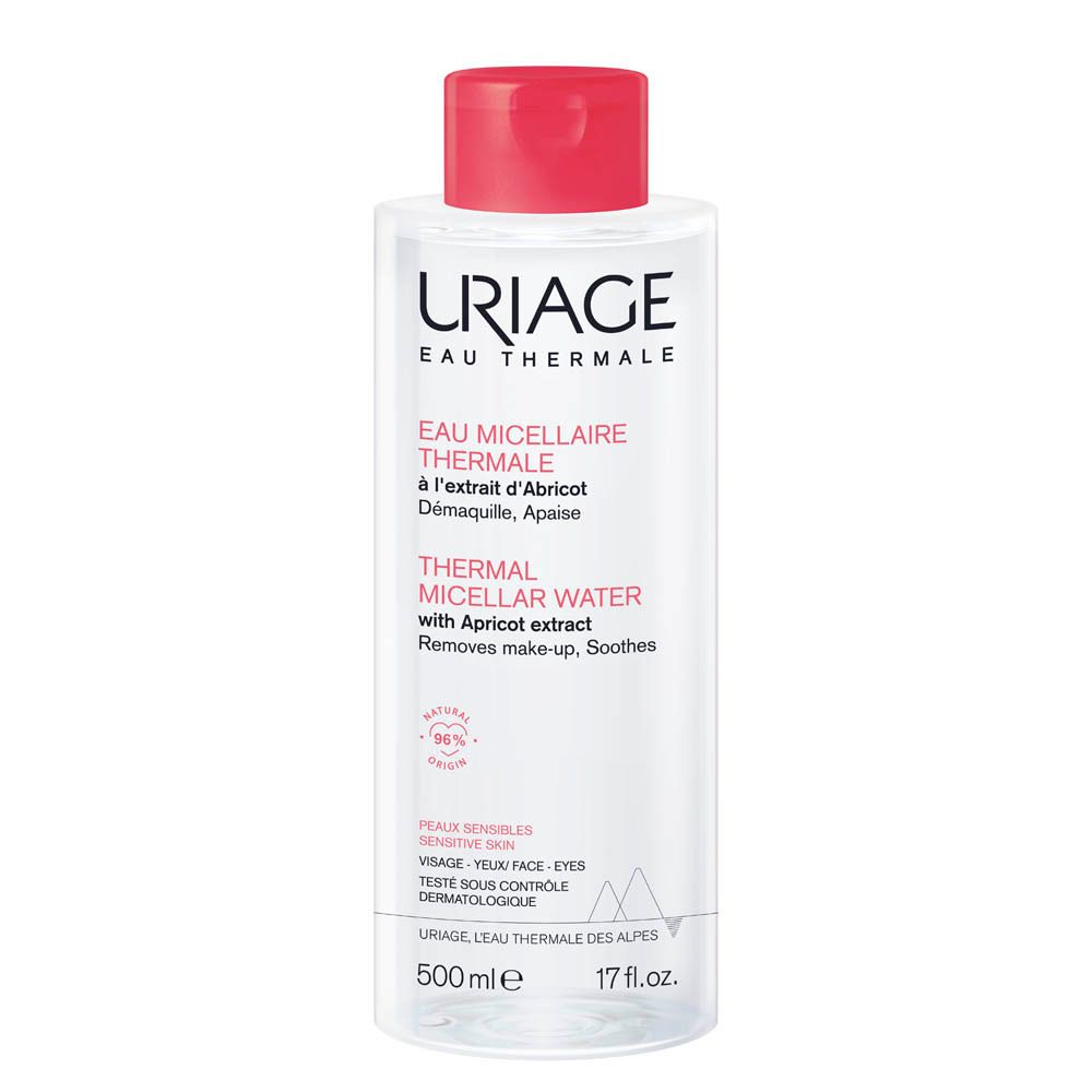 Transparante fles met rode dop. Opschrift: Uriage Eau Micellaire Thermale. Met abrikozenextract. Voor gevoelige huid.