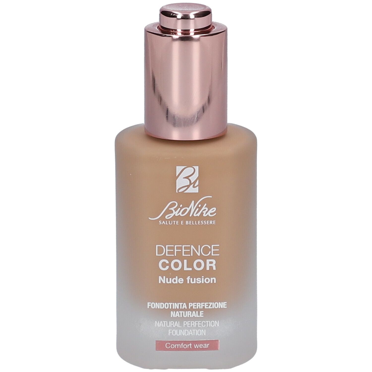 Foundationfles met roségouden dop. Opschrift: DEFENCE COLOR Nude fusion. Lichtbruine inhoud.