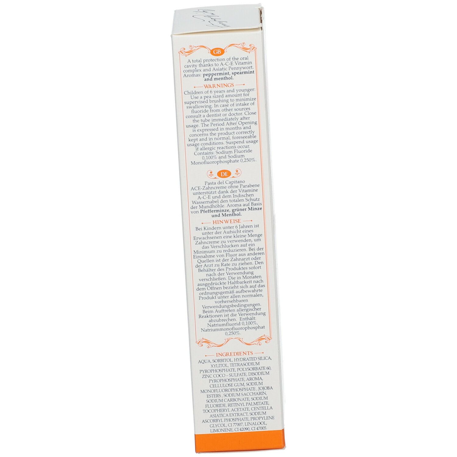 Tandpasta doos, achterkant. Tekst in meerdere talen. Bevat waarschuwingen en ingrediënten. Oranje accenten.