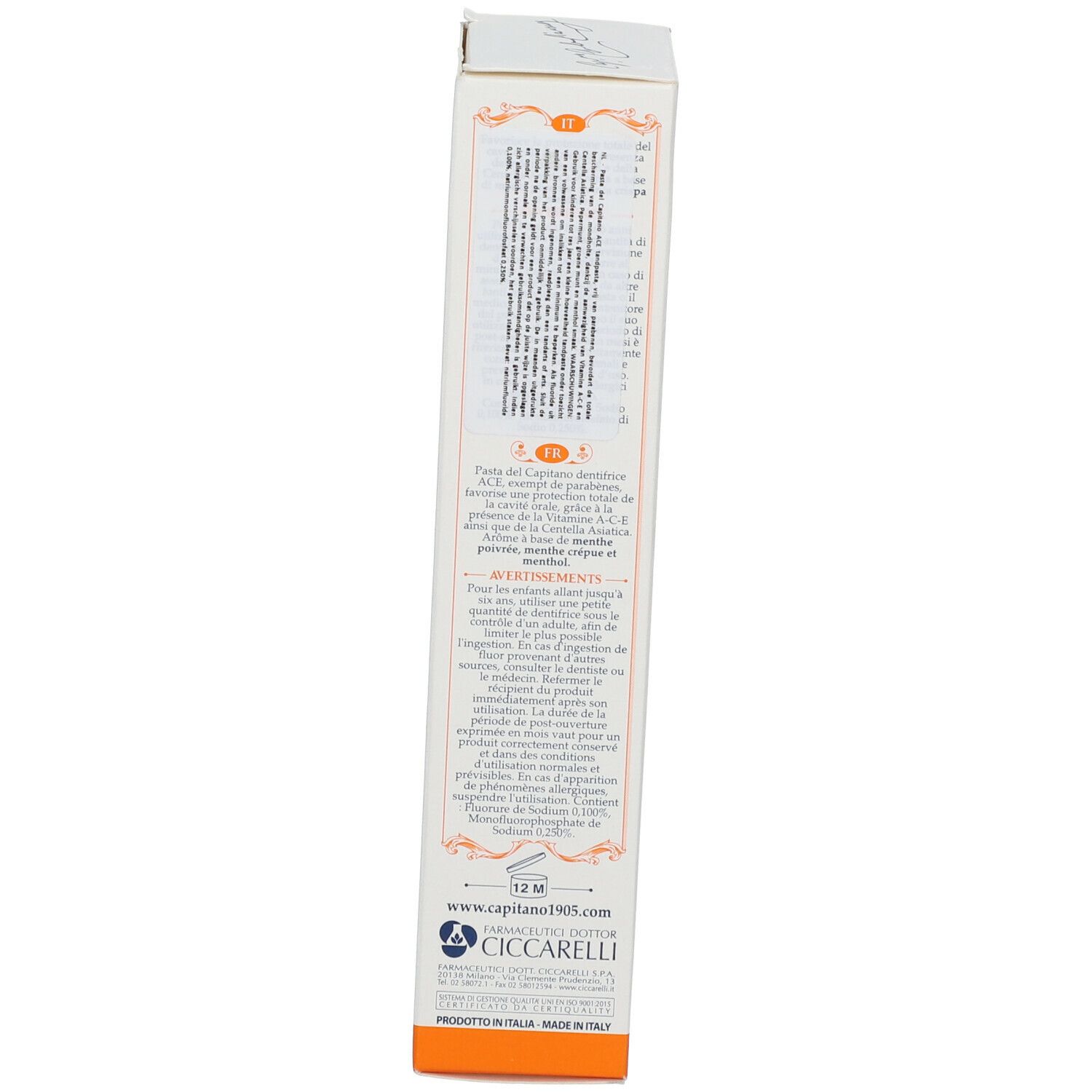 Tandpasta doos, achterkant. Tekst in meerdere talen. Bevat waarschuwingen en ingrediënten. Oranje accenten.