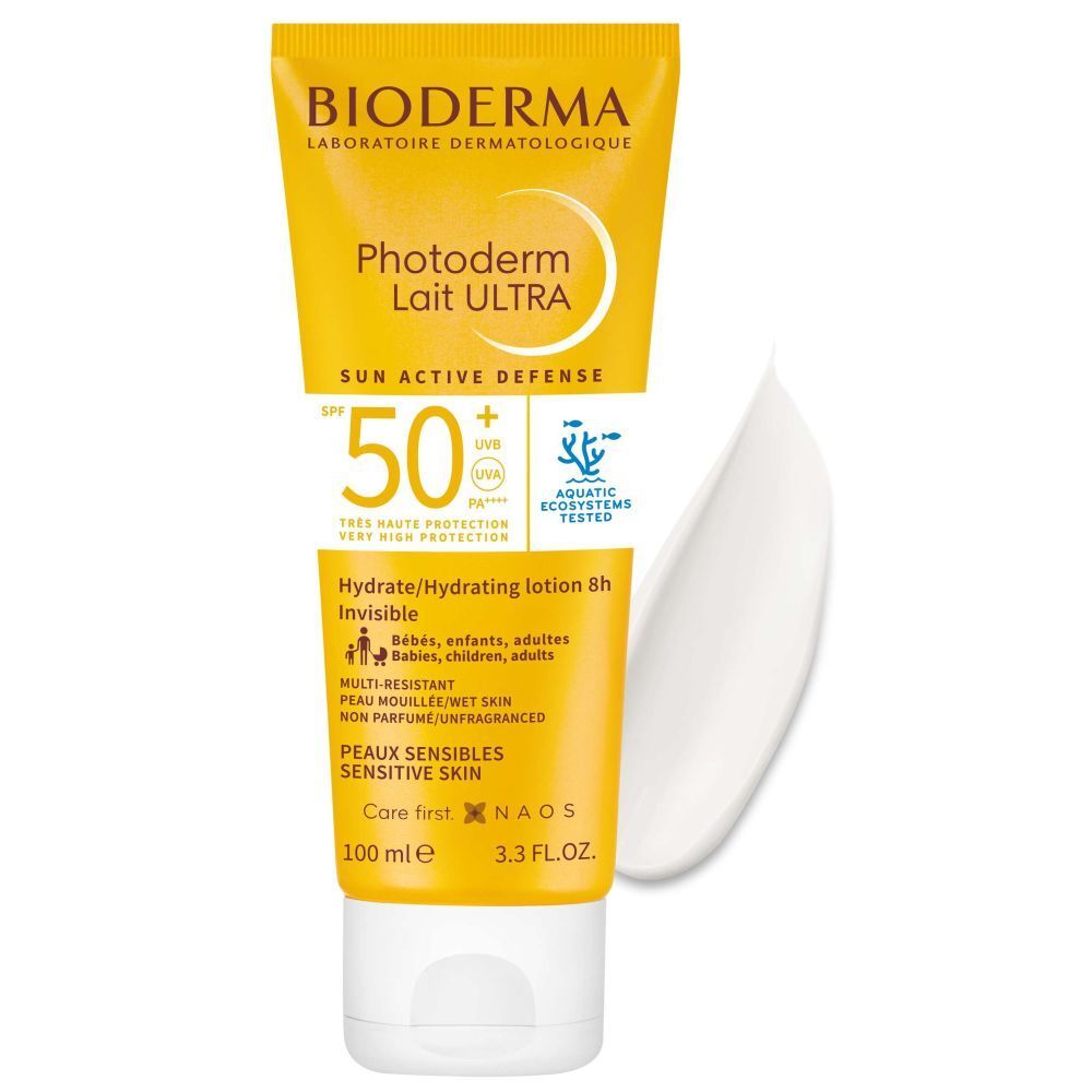 Tube jaune avec bouchon blanc. BIODERMA, Photoderm Lait ULTRA SPF50+. À côté, une goutte de crème.