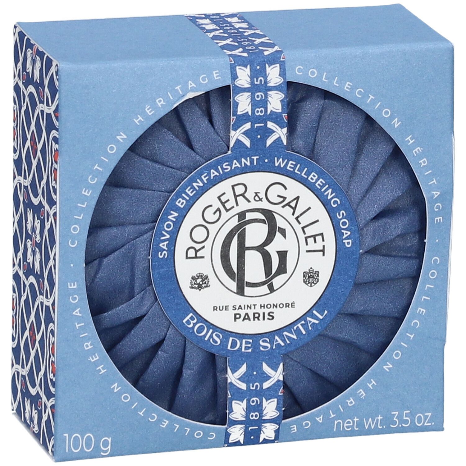 Blaue Seife in einer blauen Schachtel. Die Schachtel hat ein rundes Fenster, durch das die Seife sichtbar ist. Auf der Verpackung steht "Roger & Gallet".