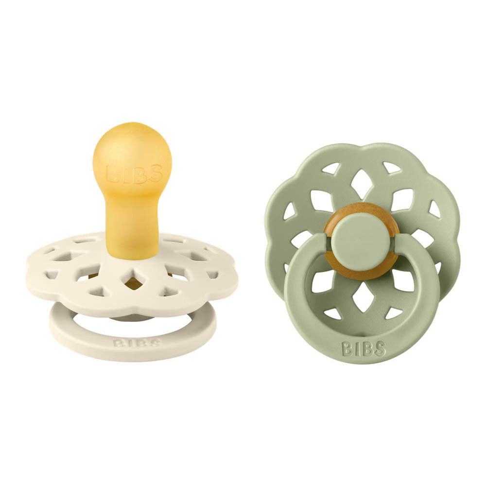 Deux sucettes, une crème, une vert sauge. Tétine ronde et bouclier en forme de fleur.