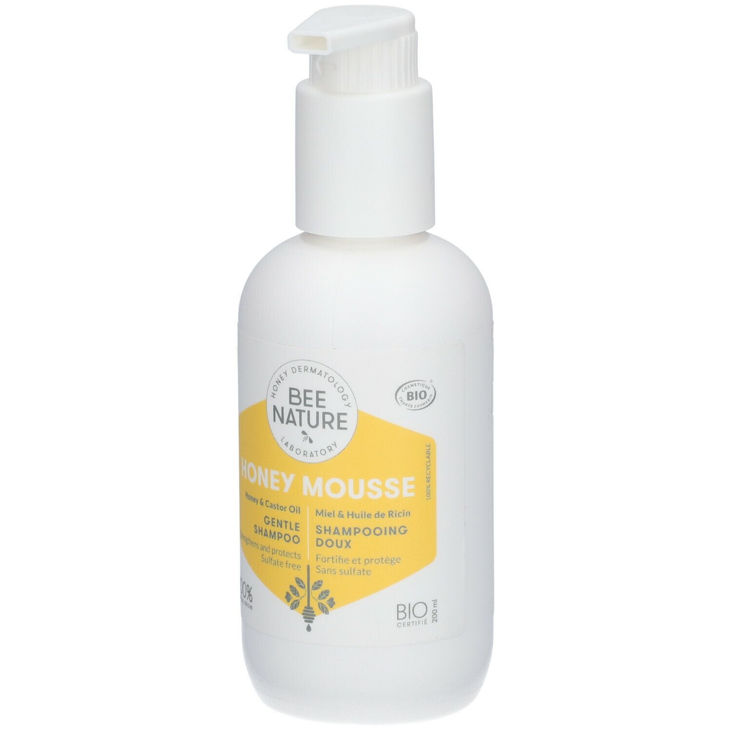 Flacon blanc avec pompe. Étiquette jaune avec texte: Honey Mousse, Gentle Shampoo. Certification Bio.