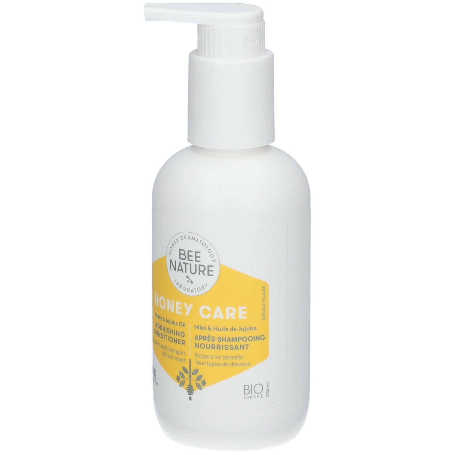 Flacon blanc avec pompe. Étiquette jaune avec texte: Honey Care, Nourishing Conditioner, Après-shampooing nourrissant.