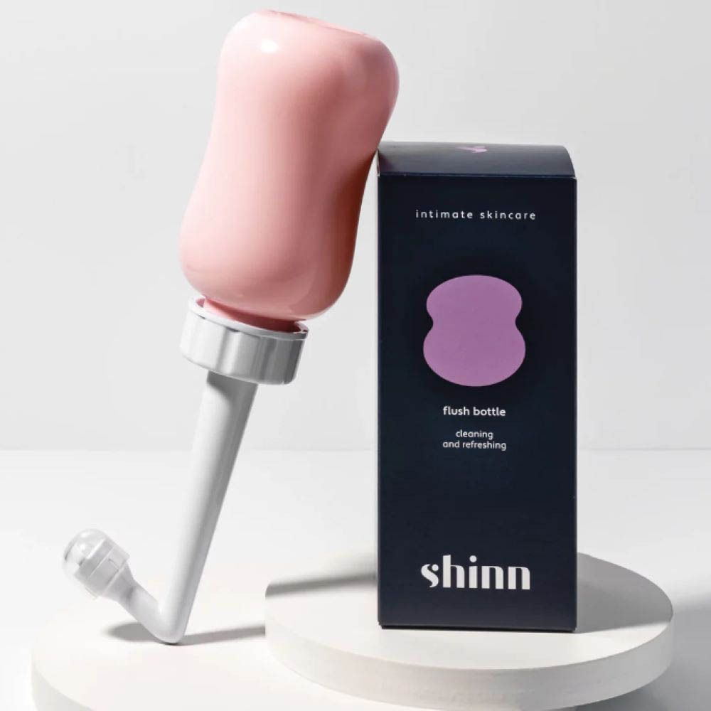 Roze spoelfles met witte opzet en verpakking. Opschrift: Intimate Skincare.