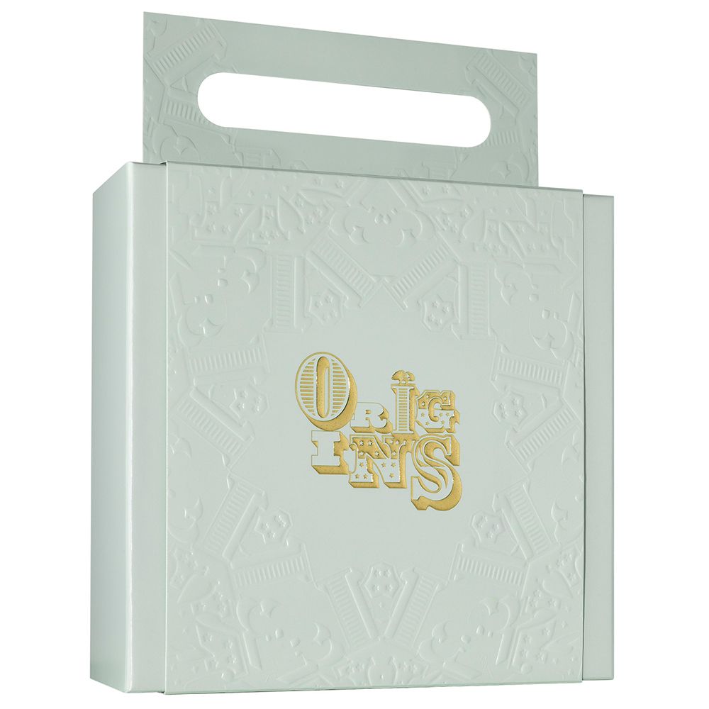 Geschenkbox in Weiß mit Prägung und Griff. Goldfarbener Schriftzug "ORIGINS" auf der Vorderseite.