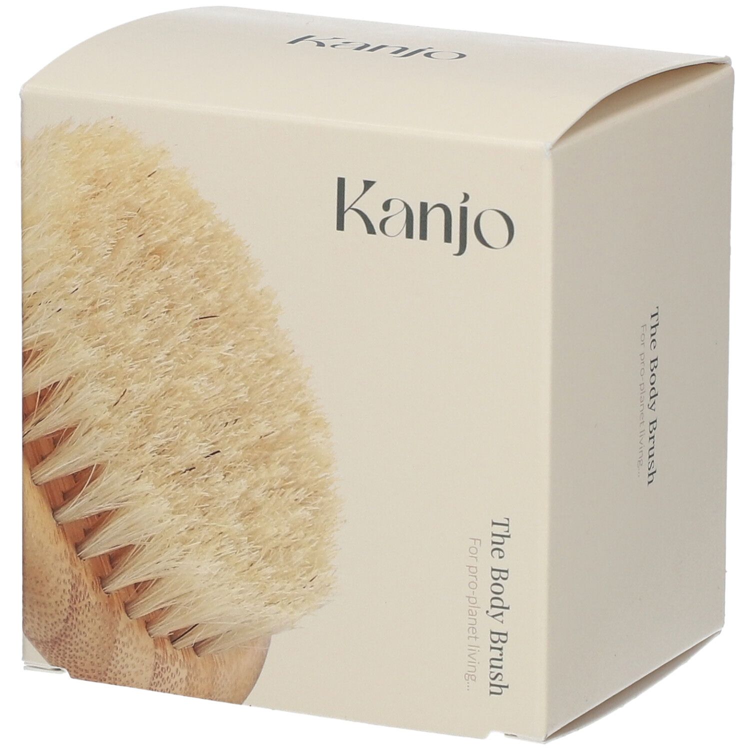 Brosse corporelle dans un emballage crème. Inscription "Kanjo" et "The Body Brush".