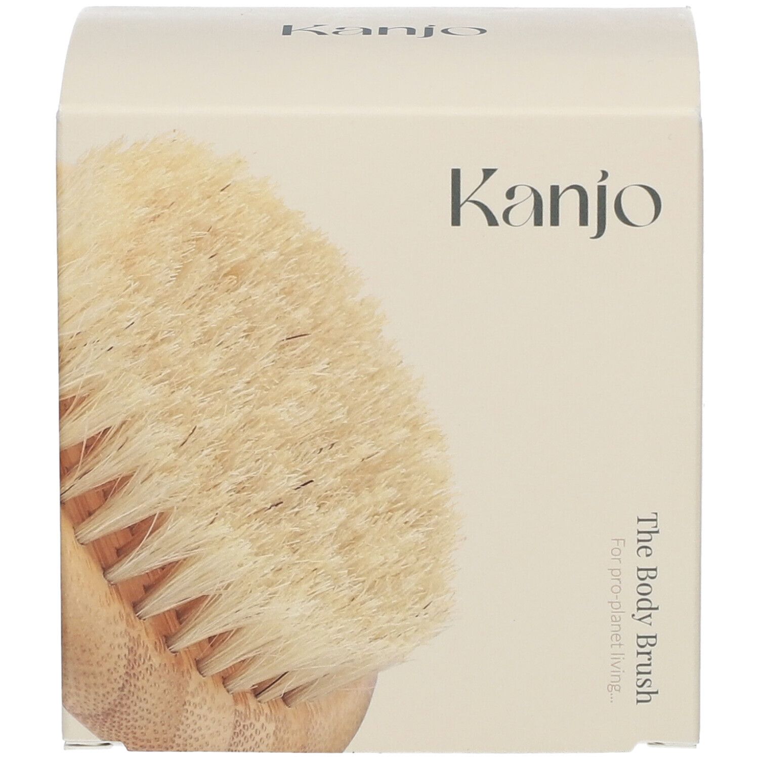 Brosse corporelle dans un emballage crème. Inscription "Kanjo" et "The Body Brush".
