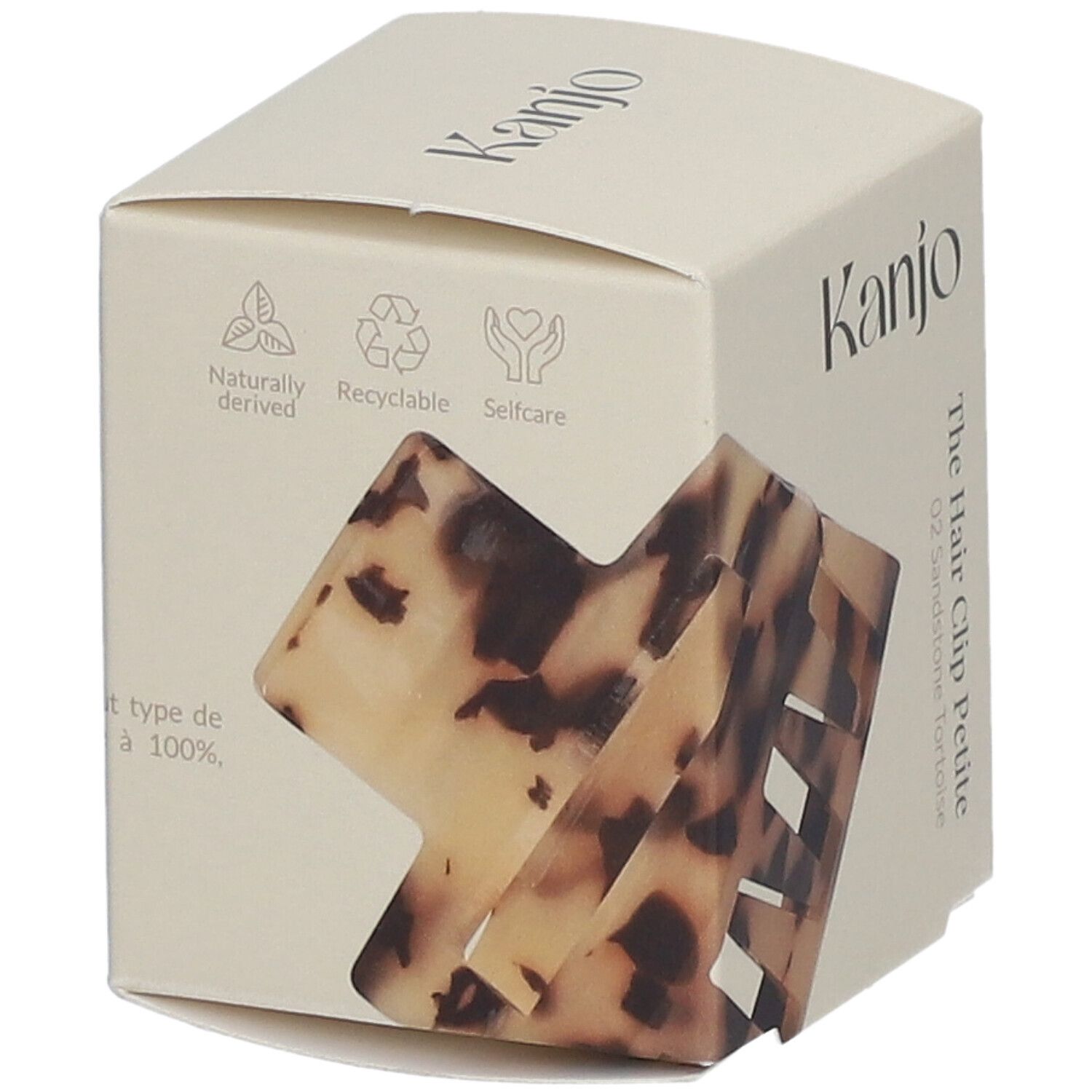 Emballage en carton avec logo Kanjo et nom du produit. La pince à cheveux Petite 02 Sandstone Tortoise est partiellement visible.