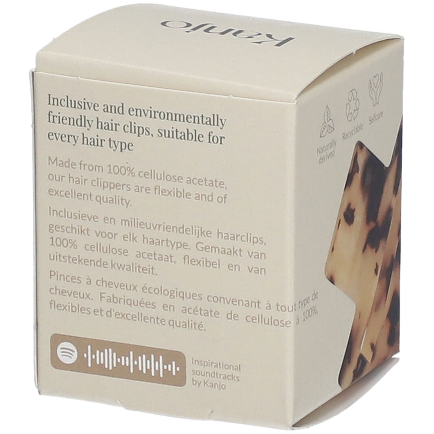 Emballage en carton avec texte et logos. Contient des informations sur les ingrédients et l'éco-responsabilité des pinces à cheveux.