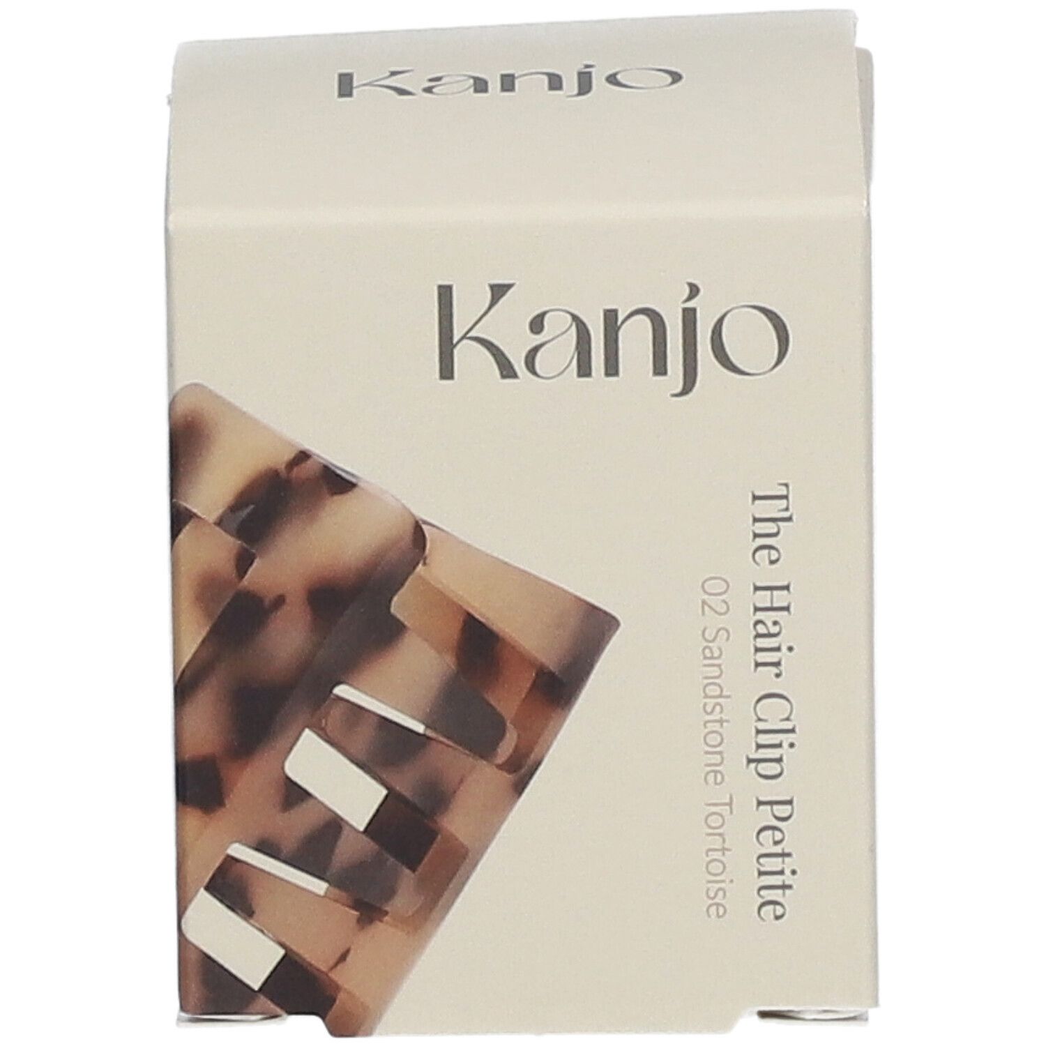 Emballage en carton avec logo Kanjo et nom du produit. La pince à cheveux Petite 02 Sandstone Tortoise est partiellement visible.